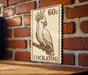 A wooden table with a wooden surface, and a wooden wall with a brick pattern. There is a wooden sign with a drawing of a bird, specifically a cockatoo, on it.