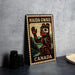 A metal sign with a stamp-like design, featuring a stylized illustration of a bear and the text "HAIDA GWAII CANADA" on it, is displayed on a table.