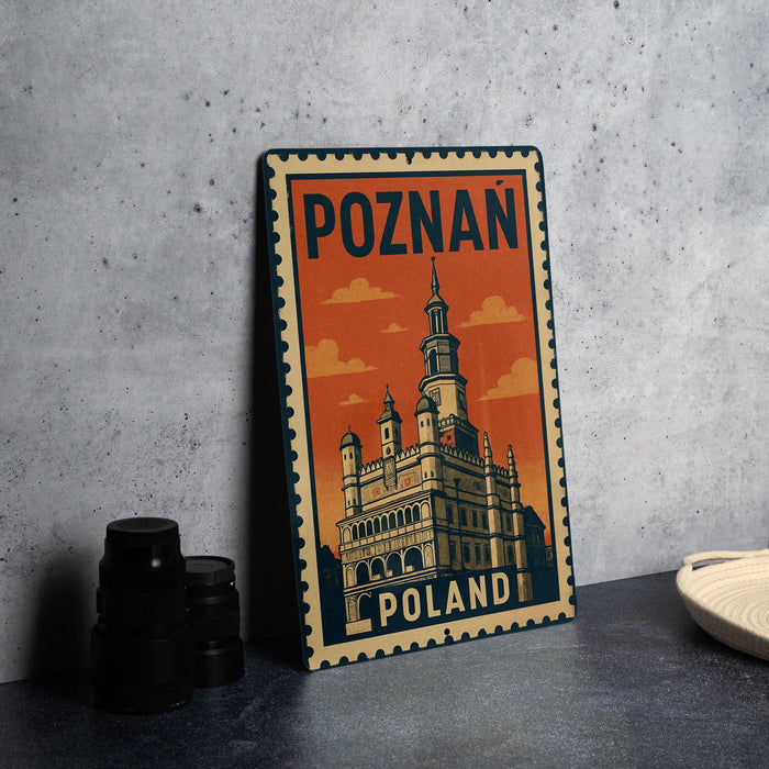 A metal sign with the text "POZNAN POLAND" and an illustration of a castle-like building, placed on a table next to some black camera lenses.