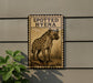 a sign with a spotted hyena illustration, mounted on a wall next to a plant.