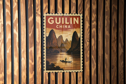 A vintage postage stamp depicting a scenic landscape with mountains, a river, and a person in a boat, hanging on a wooden wall.