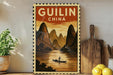 a framed vintage-style poster of Guilin, China, depicting a person in a boat on a river surrounded by mountains.