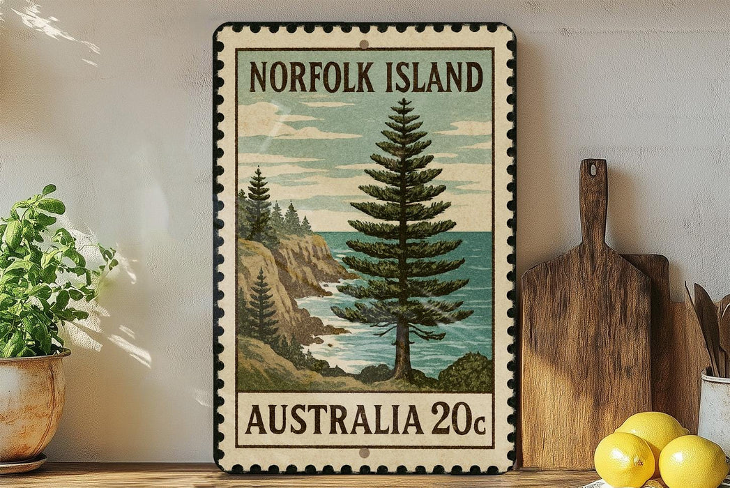 A vintage postage stamp from Norfolk Island, featuring a pine tree and a coastal landscape, is displayed on a shelf next to a wooden cutting board and a potted plant.
