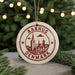 A circular ornament with the text "AARHUS DENMARK" printed on it, featuring a stylized illustration of a cityscape.