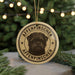 A circular ornament featuring a dog's face and the text "AFFENPINSCHER" is displayed in front of a blurred Christmas tree with twinkling lights.
