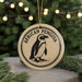 A round ornament featuring an illustration of an African penguin, with the text "African Penguin" written around the edge.