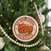A circular ornament on a Christmas tree, featuring a picture of a city and the text "AIT BENHADDOU MOROCCO".