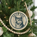 A Christmas tree decorated with ornaments, including a circular ornament with a picture of a dog and the text "AKITA DOG" on it.