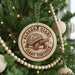 A round ornament on a Christmas tree featuring a tortoise.