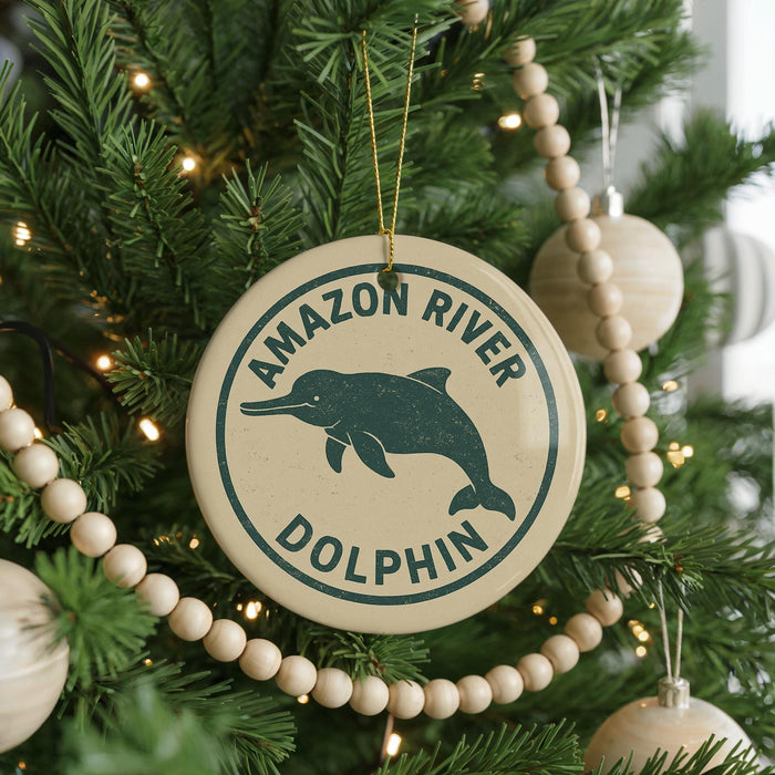 A Christmas tree decorated with ornaments, including a round ornament with a dolphin image and the text "AMAZON RIVER DOLPHIN".