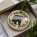 A circular ornament with the text "AMERICAN BLACK BEAR" printed on it, featuring a black bear image.
