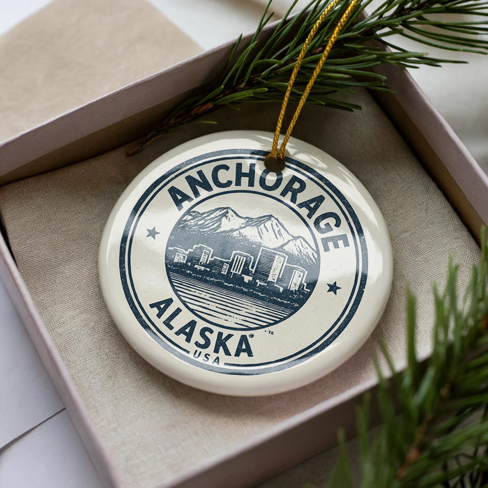 A circular ornament with the text "ANCHORAGE ALASKA USA" printed on it, surrounded by pine branches.