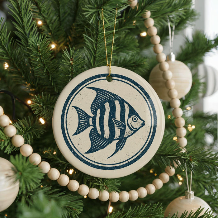 A Christmas tree decorated with ornaments, including a round ornament with a blue and white fish design.