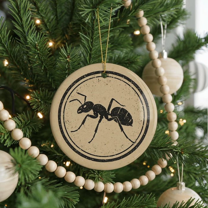 A Christmas tree decorated with ornaments, including a circular ornament with a black ant design.