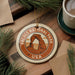 A circular ornament with the text "ARCHES NATIONAL PARK USA" and an illustration of a rock formation, hanging on a wooden surface.