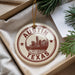 A circular ornament with the text "AUSTIN TEXAS" printed on it, surrounded by a star symbol, is displayed in a box with pine branches.