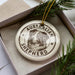 A circular ornament with the text "AUSTRALIAN SHEPHERD" and an image of a dog's head is displayed in a box, surrounded by pine branches.