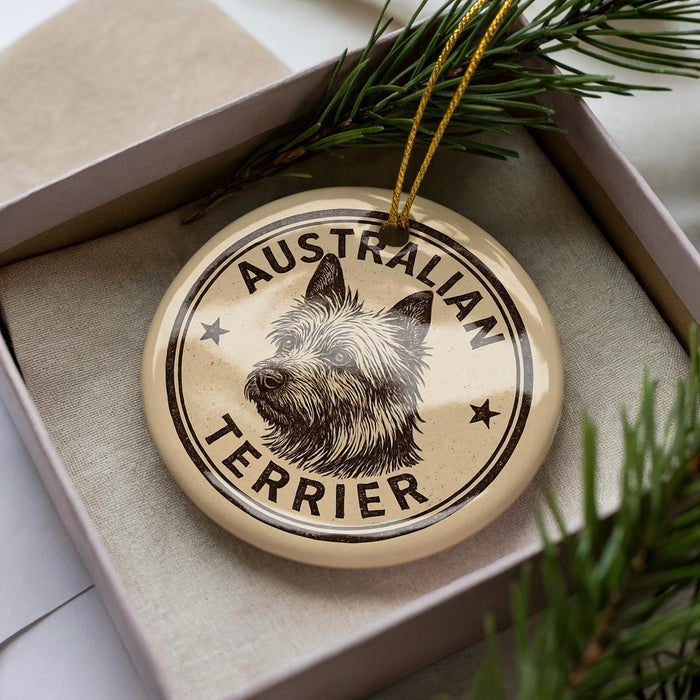 A circular ornament with the text "AUSTRALIAN TERRIER" printed on it, featuring a stylized illustration of a terrier dog's head.
