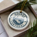 A decorative ornament in a box, featuring the text "AZORES PORTUGAL" and a landscape illustration.