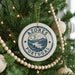 A Christmas tree decorated with ornaments, including a circular ornament with the text "AZORES PORTUGAL" and a landscape scene.