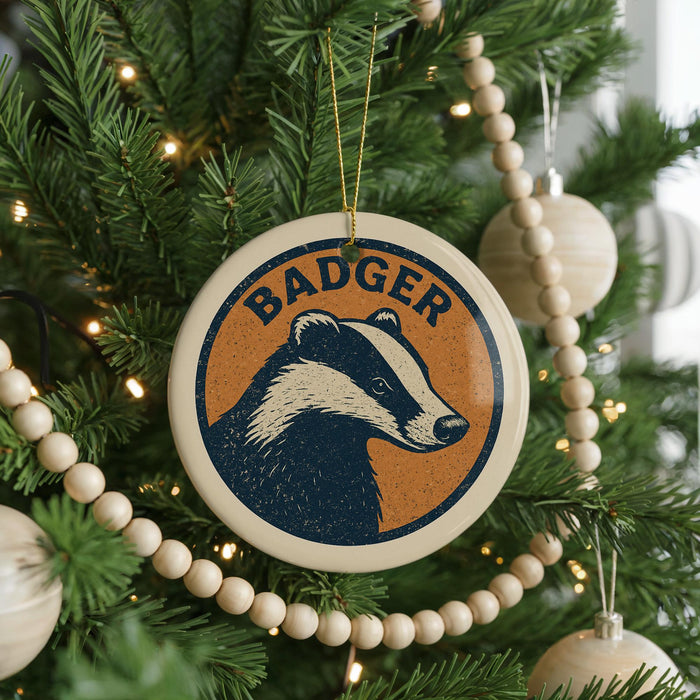 A Christmas tree decorated with ornaments, including a circular ornament with a badger image and the word "BADGER" written on it.