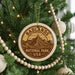 A Christmas tree decorated with ornaments, including a circular ornament with the text "Badlands National Park USA" and a mountain landscape design.