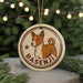 A circular ornament featuring a brown and white dog, with the name "Basesenji" written around the edge.