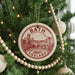 A circular ornament on a Christmas tree, featuring a drawing of a city and the text "BATH ENGLAND".