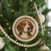 A Christmas tree decorated with ornaments, including a circular ornament featuring a beagle dog's face.