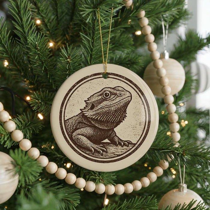 A Christmas tree decorated with ornaments, including a circular ornament featuring a bearded dragon illustration.