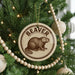 A Christmas tree decorated with ornaments, including a circular ornament with a beaver image and the word "BEAVER" written on it.