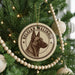 A Christmas tree decorated with ornaments, including a circular ornament featuring a dog's head and the text "Belgian Malinois".