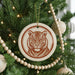 A Christmas tree decorated with ornaments, including a large circular ornament featuring a tiger's face.