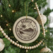 A Christmas tree decorated with ornaments, including a circular ornament with the text "BÉQUIA Saint Vincent and the Grenadines" and a palm tree design.