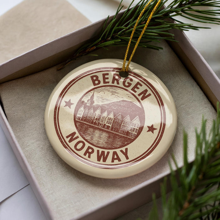 A circular ornament with the text "BERGEN NORWAY" printed on it, surrounded by pine branches.