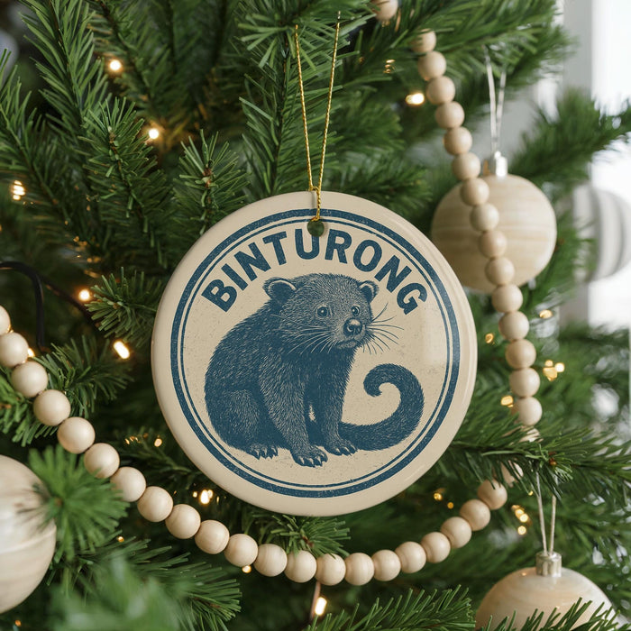 A Christmas tree decorated with ornaments, including a circular ornament with a picture of a small animal and the word "Binturong" written on it.