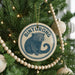 A Christmas tree decorated with ornaments, including a circular ornament with a picture of a small animal and the word "Binturong" written on it.
