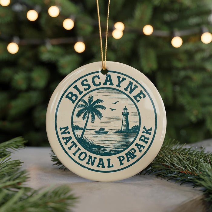 A circular ornament with the text "BISCAYNE NATIONAL PAPARK" and a graphic of a lighthouse and palm tree, hanging from a string.