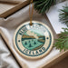 A circular ornament with the text "BLUE LAGOON ICELAND" and an illustration of a lake with people swimming, hanging from a string.
