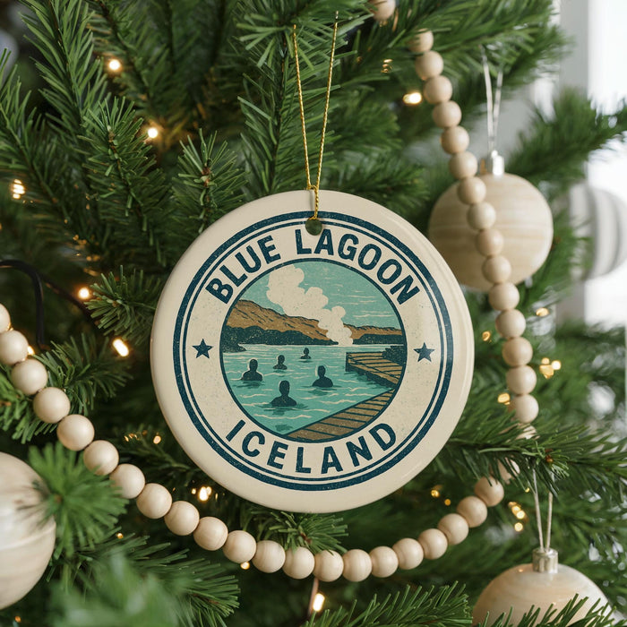 A Christmas tree decorated with ornaments, including a circular ornament with the text "BLUE LAGOON ICELAND" and a scenic illustration of a lake and mountains.