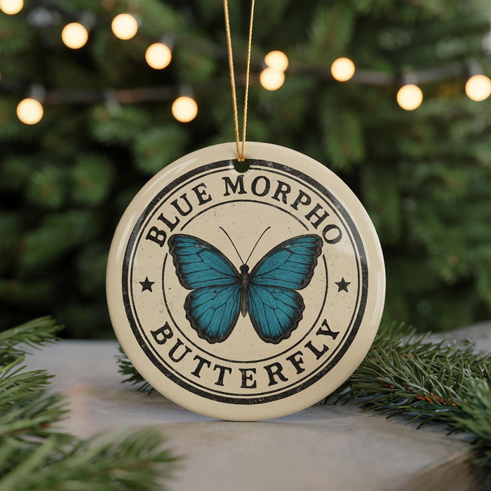 A circular ornament with a blue butterfly design and the text "BLUE MORPHO BUTTERFLY" printed on it, hanging from a string.