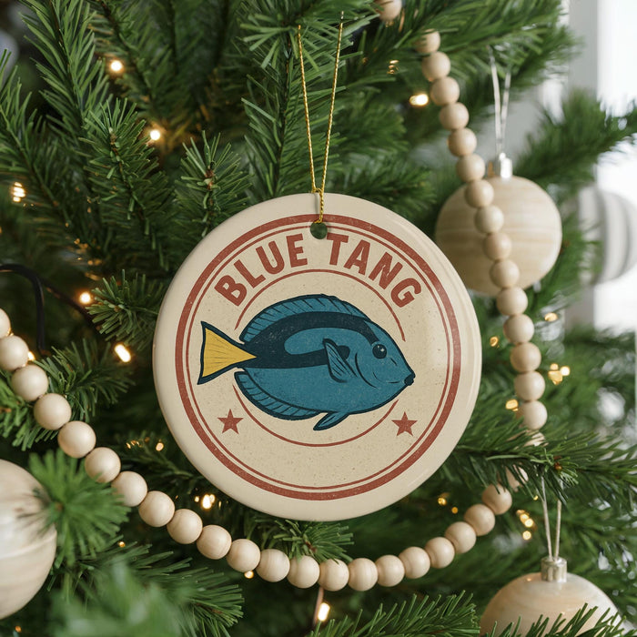 A Christmas tree decorated with ornaments, including a circular ornament with a blue fish and the text "BLUE TANG" on it.