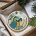 A circular ornament with a parrot design, featuring the text "BLUE AND YELLOW MACAW" around the edge.