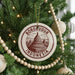 A round ornament on a Christmas tree, featuring an illustration of Borobudur temple in Indonesia.