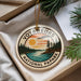 A circular ornament with the text "VOYAGUEURS NATIONAL PAPARK" and an illustration of a sunset over a lake surrounded by pine trees.