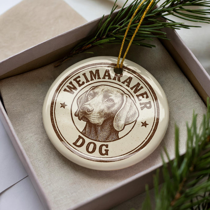 A round ornament with the text "Weimaraner Dog" printed on it, featuring a dog's head image.