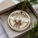 A round ornament with the text "Weimaraner Dog" printed on it, featuring a dog's head image.