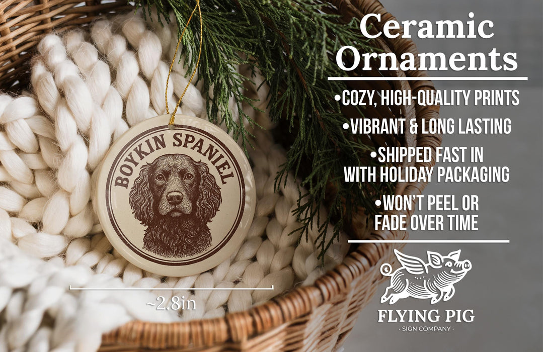 Ceramic ornaments featuring a Borkin Spaniel dog, with a wicker basket and greenery in the background.