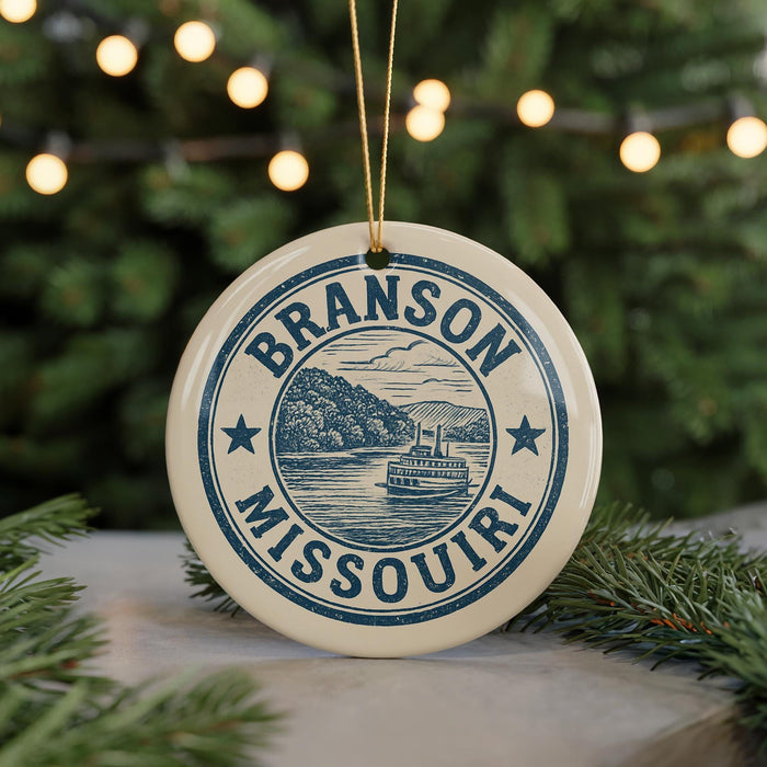 A circular ornament with the text "BRANSON MISSOURI" and an illustration of a river and a boat, hanging from a string.