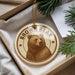 A brown bear ornament with the text "Brown Bear" is displayed in a box, surrounded by pine branches.